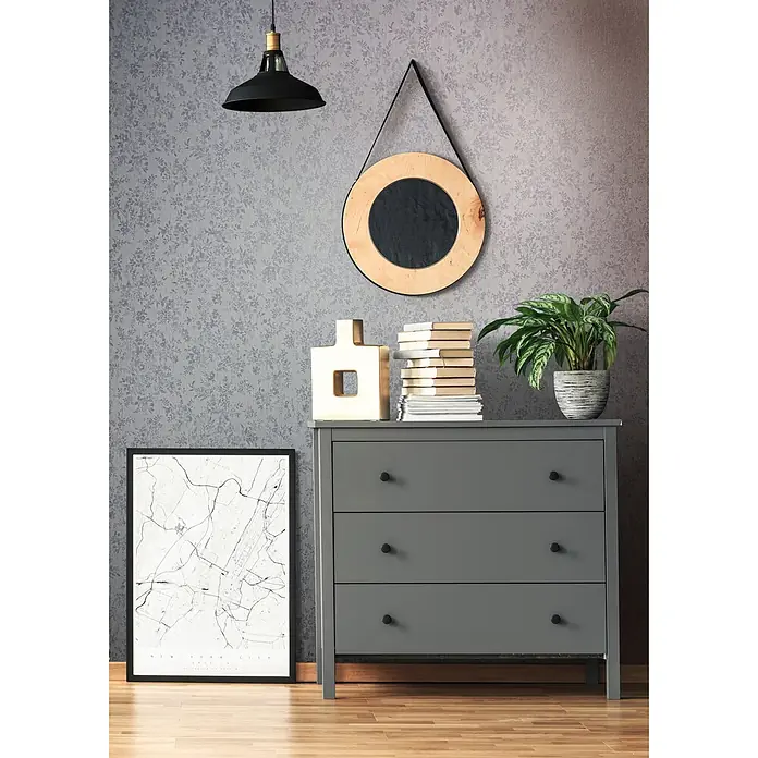 Livingwalls Vliestapete Grafisch, blau - 10.050 x 530 mm - Eine graue Kommode mit drei Schubladen und schwarzen Griffen steht in einem Raum, dekoriert mit Büchern und einer Pflanze.