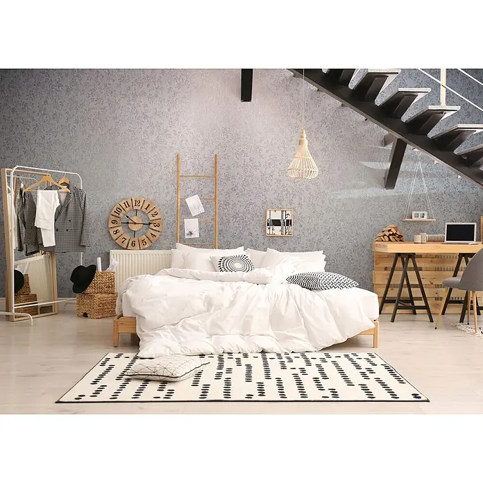 Livingwalls Vliestapete Grafisch, blau - 10.050 x 530 mm - Ein gemütliches modernes Schlafzimmer mit gemusterter Wand, einem Bett mit weißer Leinenwäsche, einem hellen Holzschreibtisch und einem Kleiderständer.