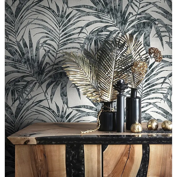 Livingwalls Vliestapete Floral, schwarz-weiß - 10.050 x 530 mm - Tapete mit grauem Palmenblattmuster auf hellem strukturiertem Hintergrund, an einer Wand hinter einer Konsole.
