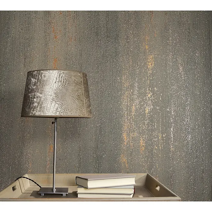 Livingwalls Vliestapete Struktur, anthrazit - anthrazit - Eine Tischlampe mit grauem Krokodil-Schirm und Metallsockel steht auf einem Holztablett mit Büchern.