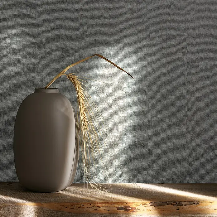 Livingwalls Vliestapete Struktur, greige - 10.050 x 530 mm - Matte dunkelgraue Vase mit goldenen getrockneten Weizenähren auf rustikaler Holzoberfläche, von Naturlicht beleuchtet.