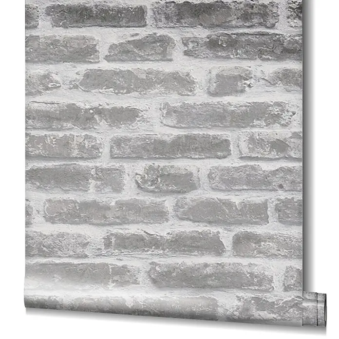 Livingwalls Vliestapete Steinoptik, greige - 10.050 x 530 mm - Graue Tapetenrolle mit Ziegelsteinmuster, abgerollt zeigt sie das hellgraue und weiße Steinmuster.