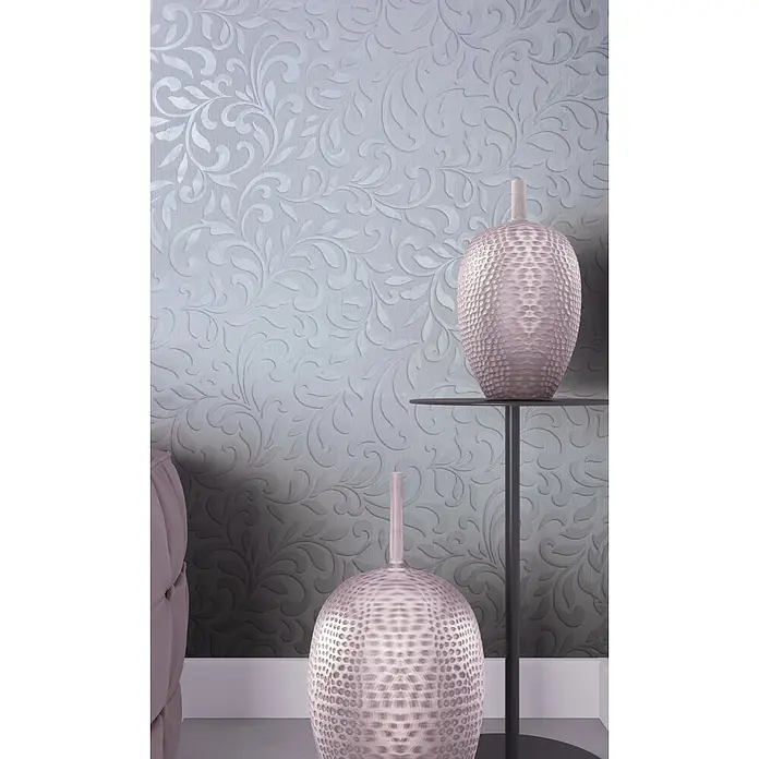Livingwalls Vliestapete Grafisch, grau, pearl - 10.050 x 530 mm - Zwei dekorative, gehämmert wirkende Vasen in Roségold, eine auf einem Tisch und eine auf dem Boden, vor einer gemusterten Wand.