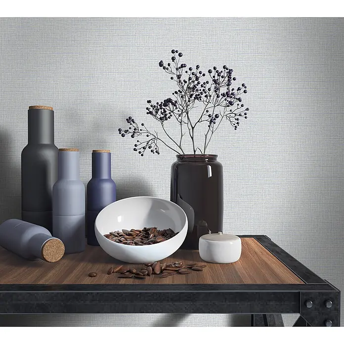 Livingwalls Vliestapete Uni, beige -  - Dekorative Flaschen, eine weiße Schale mit Samen und eine dunkle Vase mit lila Beeren auf einem Holzregal.