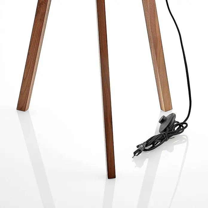 Lucande Stehleuchte Auriane - Holz dunkel, schwarz, E27 - Drei braune Holzbeine einer Lampe mit schwarzem Stromkabel, inklusive Fußschalter und einem zweipoligen Stecker.