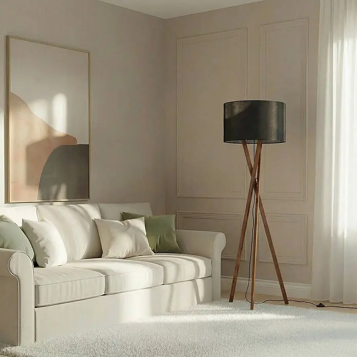 Lucande Stehleuchte Auriane - Holz dunkel, schwarz, E27 - Stehlampe mit schwarzem zylindrischem Schirm und Holz-Dreibein, neben einem cremefarbenen Sofa.