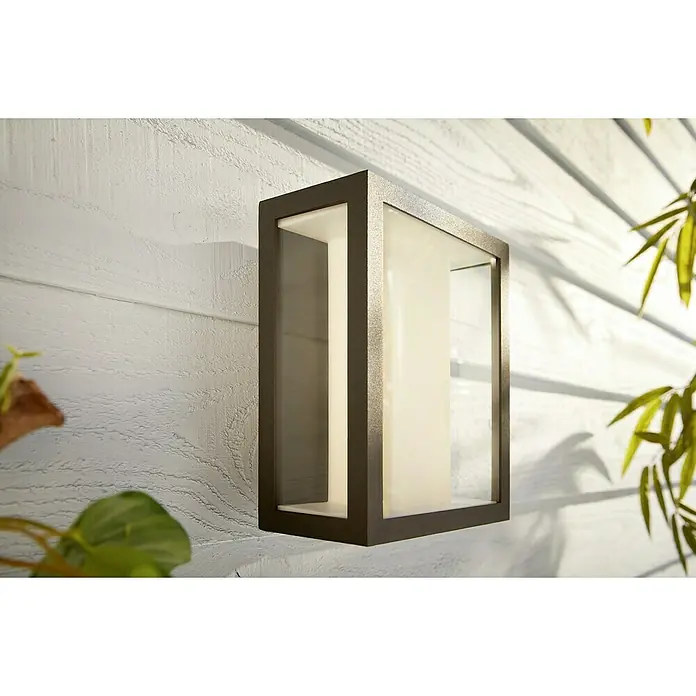 Philips Hue LED-Außenwandleuchte Impress - 8 W, 11,7 x 19 x 24 cm, Schwarz, IP44 - Nahaufnahme einer modernen würfelförmigen Außenwandleuchte mit einem bronzefarbenen Rahmen und einem Lichtdiffusor.