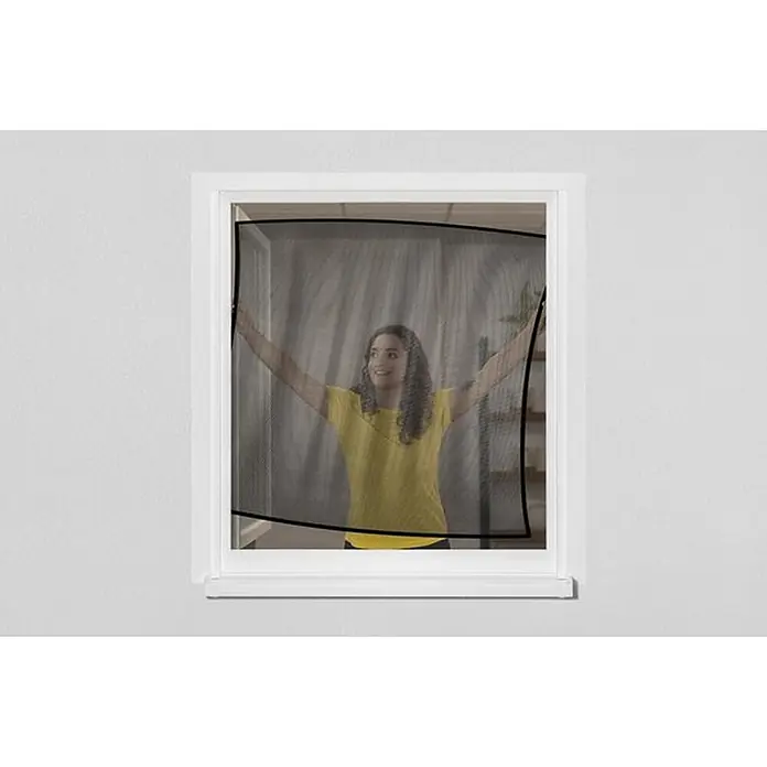 Schellenberg Mosquitera para ventana Pop Up - An x Al: 100 x 120 cm, Color bastidor: Blanco, Montaje de la mosquitera: Inserción - Mosquitera de malla negra sostenida por una persona en un marco de ventana, mostrando su material flexible y ajuste.