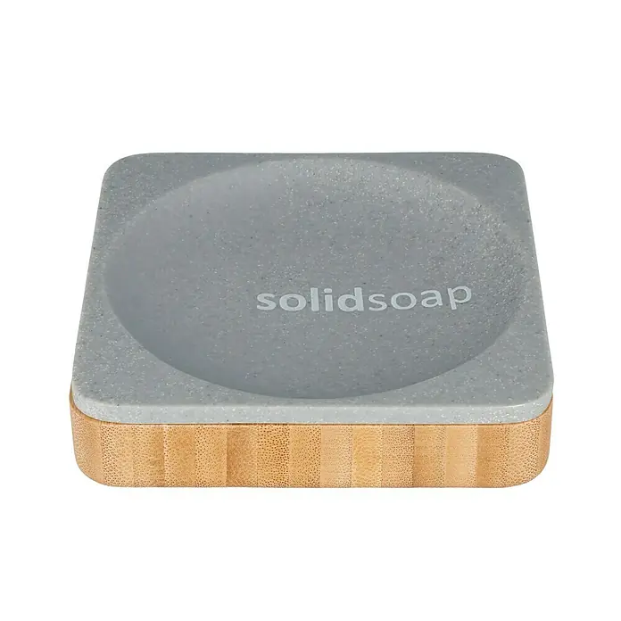 Venus Cooper Seifenschale - Polyresin, Grau - Das Solidsoap Seifenstück liegt auf einer stilvollen Seifenablage aus Bambus und grauem Material.