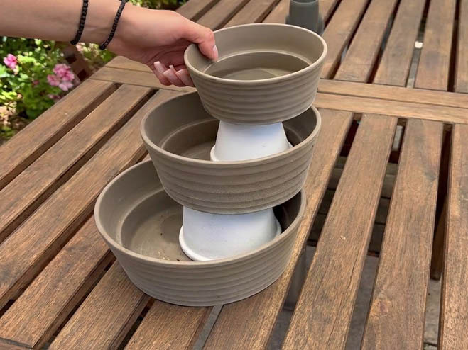 Pflanzenstapel aus Tontöpfen im Garten auf dem Esstisch