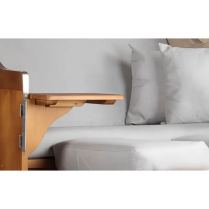 Mr. Deko Strandstuhl Strandkorb Schleswig Pinie Braun PE Mokka Dessin 563 - 1 Stk., Pinienholz. Polyrattan, Rückenlehne verstellbar, PE Mokka - Hölzernes Nachttischregal mit Metallbefestigung, neben einem Bett mit weißen Kissen und Bettwäsche.