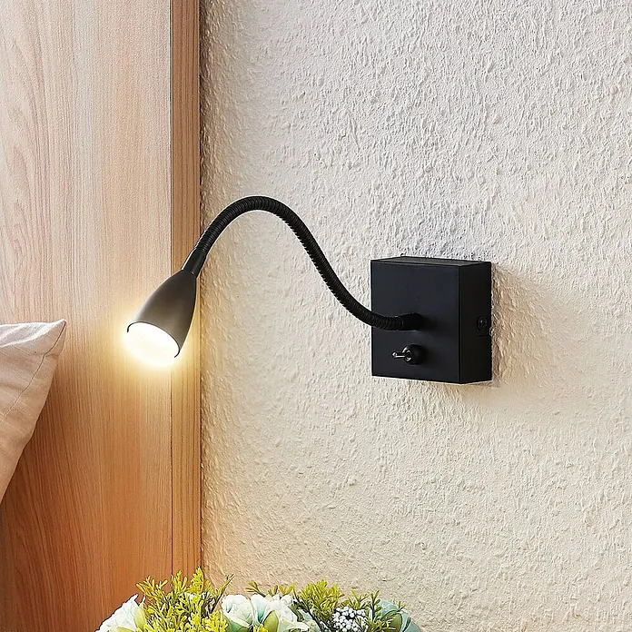 Lindby Wandleuchte Jolka - L x B x H: 30 x 7 x 15 cm, schwarz, schwarz - Schwarze wandmontierte Leselampe mit flexiblem Schwanenhals und Kippschalter, strahlt warmes Licht neben einem Bett aus.