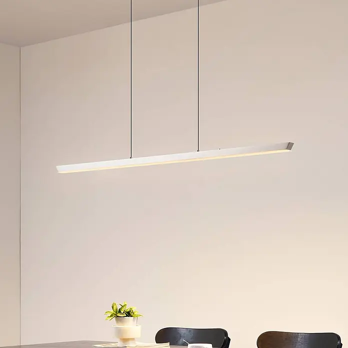 Lucande Pendelleuchte Solvar - chrom / silber, silber - Weiße lineare Pendelleuchte beleuchtet einen Essbereich.