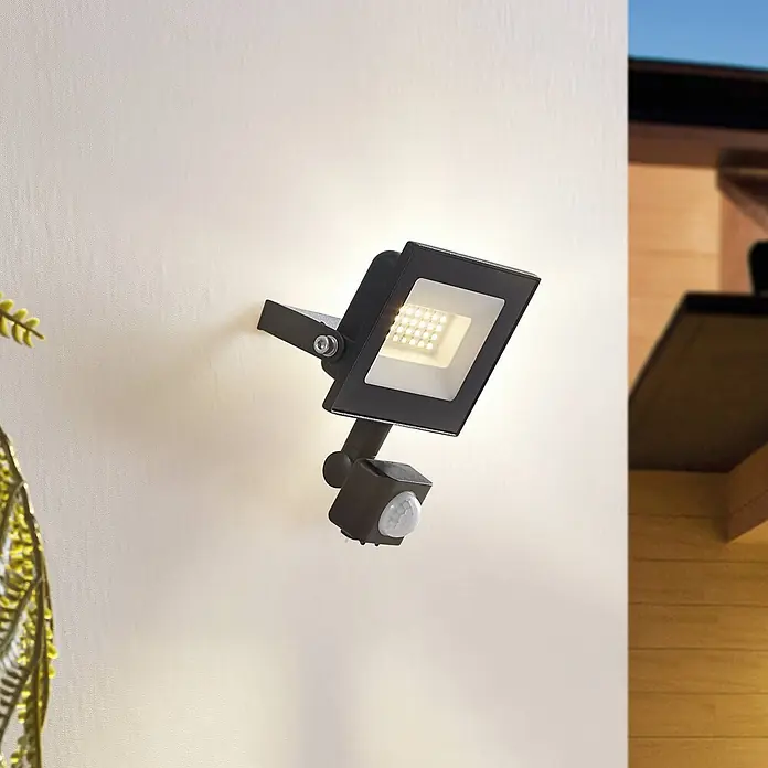 Prios Außenwandleuchte Maikel - 7,1 x 10,8 x 14,5 cm, schwarz, schwarz, IP44 - Schwarzer LED-Fluter mit Bewegungsmelder an einer Außenwand montiert, leuchtet nach unten.