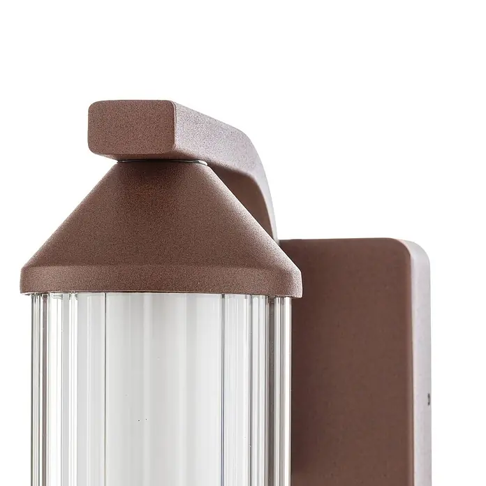 Lindby LED Wandleuchte aussen in rost, transparent, Aussenlampe Wand -  - Nahaufnahme einer dunkelbraunen, texturierten Außenwandleuchte mit einem klaren, gerippten Glasdiffusor.