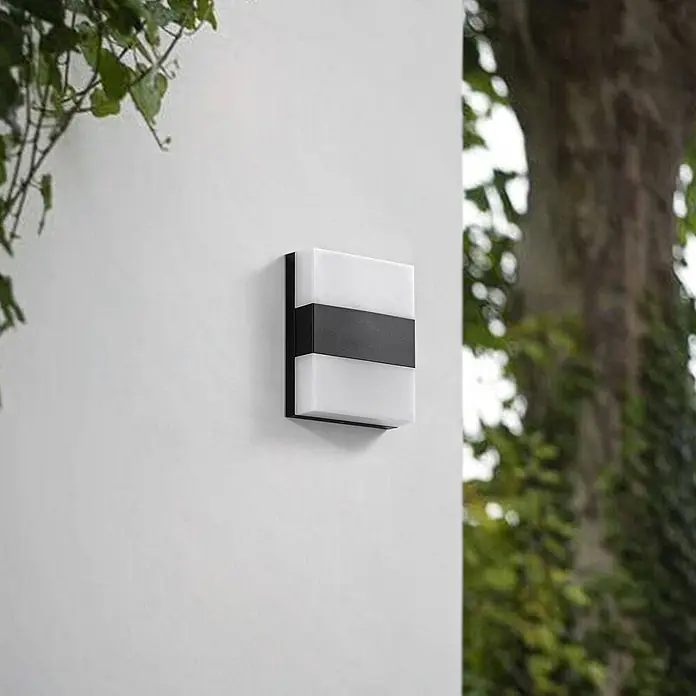 Prios Außenwandleuchte Teekon - 5,3 x 16 x 20 cm, schwarz, weiß / opal, IP44 - Rechteckige Außenwandleuchte in Schwarz mit transluzenten weißen Diffusoren, an einer Gebäudewand montiert.