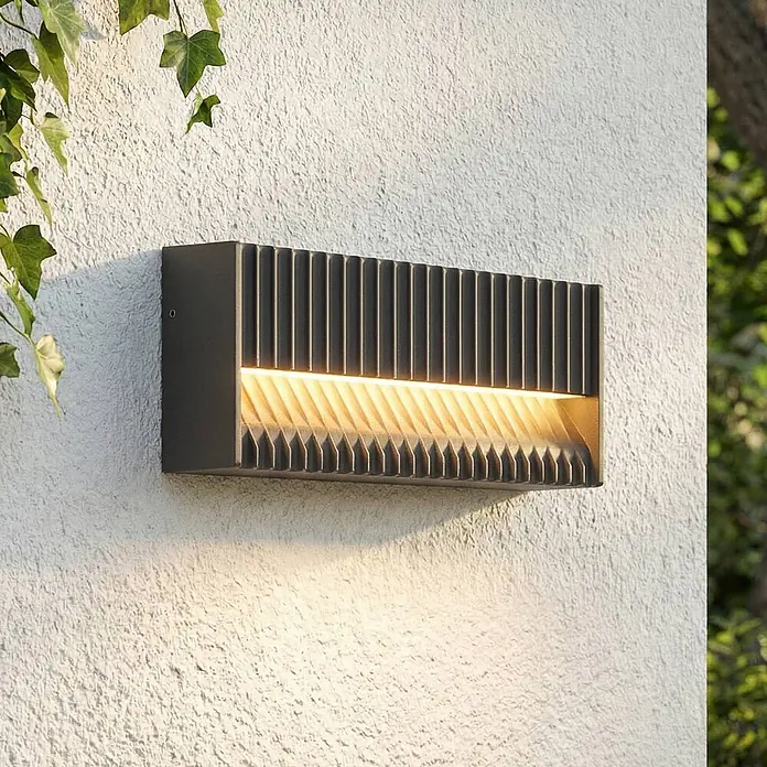 Lucande Außenwandleuchte Tavion - 4,6 x 25 x 10 cm, schwarz, schwarz, IP65 - Dunkelgraue rechteckige Außenwandleuchte mit geriffeltem Design, strahlt warmes Licht nach unten.