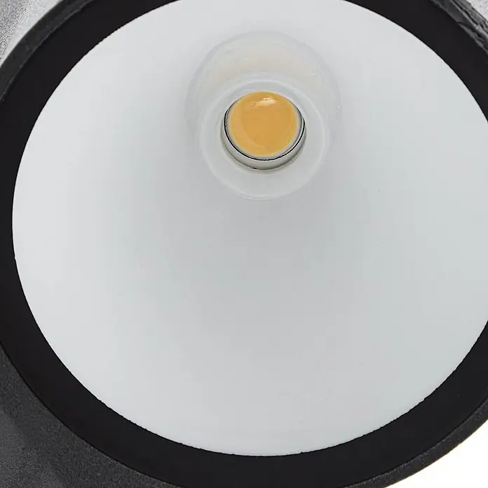 Lindby Außenwandleuchte Illuvia - schwarz, schwarz, IP44 - Rundes, bernsteinfarbenes LED-Licht in weißem, konischem Reflektor, von schwarzem Ring umrandet.