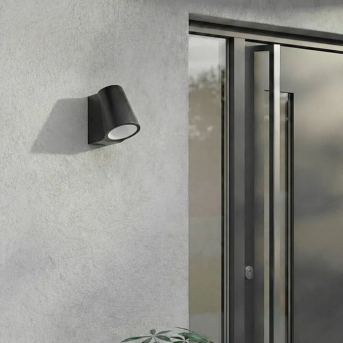 Lindby Außenwandleuchte Illuvia - schwarz, schwarz, IP44 - Schwarze konische Außenwandleuchte an grauer Wand neben moderner Tür montiert.