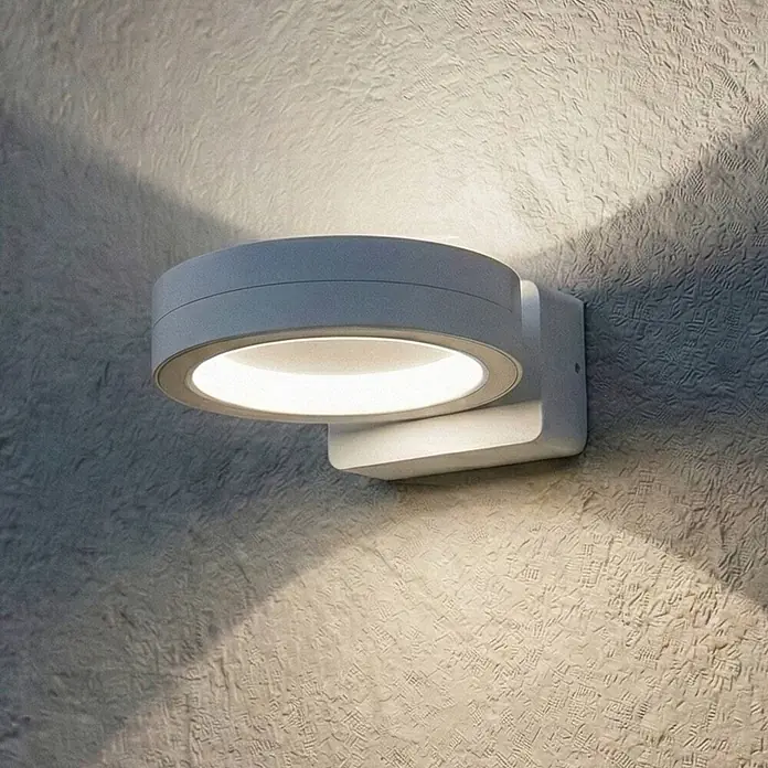 Lindby Außenwandleuchte Selviro - 24,3 x 20 x 10 cm, weiß / opal, weiß / opal, IP65 - Runde graue Wandleuchte beleuchtet eine strukturierte Wand.