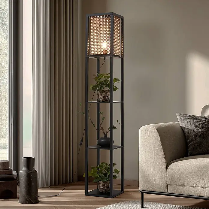 Lindby Stehleuchte Birta - schwarz, Holz hell, E27 - Stehleuchte aus schwarzem Metall mit Rattan-Schirm und Regalen, in einem Wohnzimmer platziert.