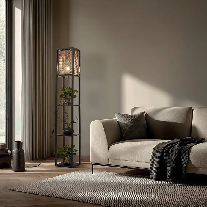 Lindby Stehleuchte Birta - schwarz, Holz hell, E27 - Hohe Stehlampe aus schwarzem Metall mit Rattan-Schirm und integrierten Regalen mit Pflanzen, neben einem beigen Sofa.