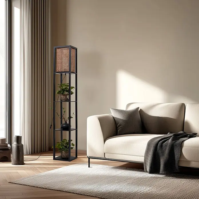 Lindby Stehleuchte Birta - schwarz, Holz hell, E27 - Schwarze Metall-Stehlampe mit Rattan-Schirm und vier Regalen für Topfpflanzen und eine Vase, neben einem beigefarbenen Sofa in einem modernen Wohnzimmer.
