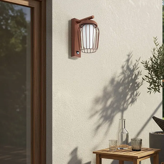 Lucande Außenwandleuchte Chandan - 23,4 x 16,5 x 30 cm, braun / rost, IP44 - Rostbraune Metall-Außenwandleuchte mit weißem Diffusor und Bewegungsmelder, an einer strukturierten cremefarbenen Wand montiert.