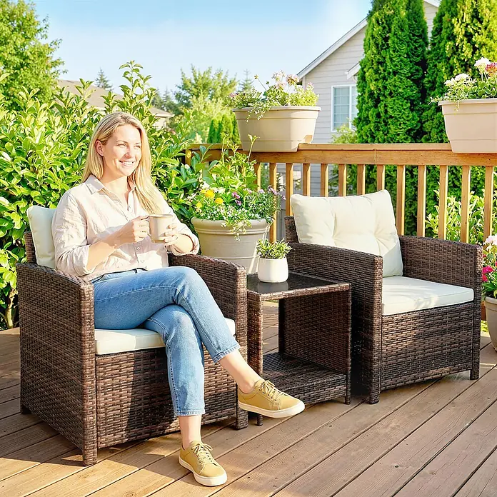 Outsunny Loungemöbel-Set - PE-Rattan (künstliches Rattan), Cremeweiß - Dunkelbraune Rattan-Garnitur mit cremefarbenen Kissen auf einer Terrasse. Eine Frau entspannt sich im Stuhl mit Tasse.