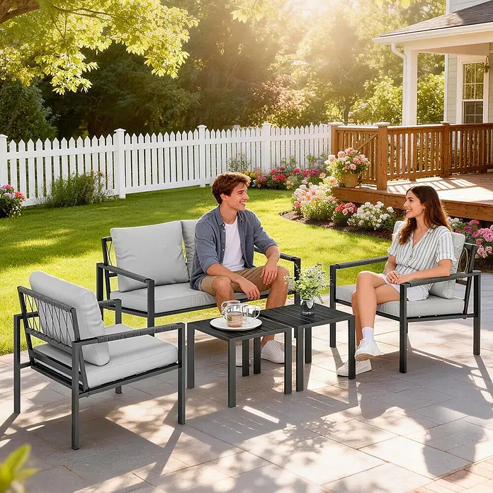Outsunny Loungemöbel-Set - Hellgrau - Schwarzes Metall-Gartenmöbelset mit hellgrauen Polstern, von zwei Personen auf einer sonnigen Terrasse genutzt.