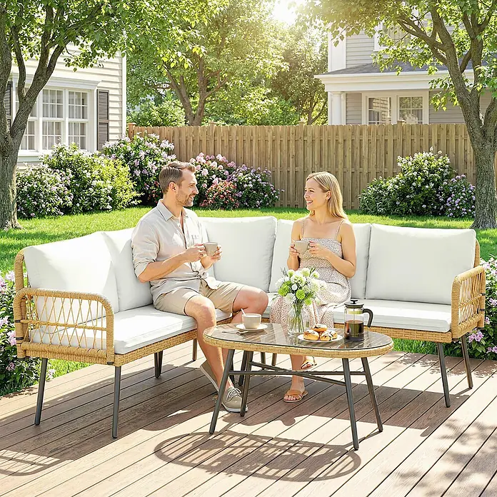 Outsunny Loungemöbel-Set - 4 -tlg., PE-Rattan, Cremeweiß - Eine L-förmige Outdoor-Sitzgruppe mit Couchtisch aus Glas auf einer Holzterrasse, auf der zwei Personen Kaffee genießen.