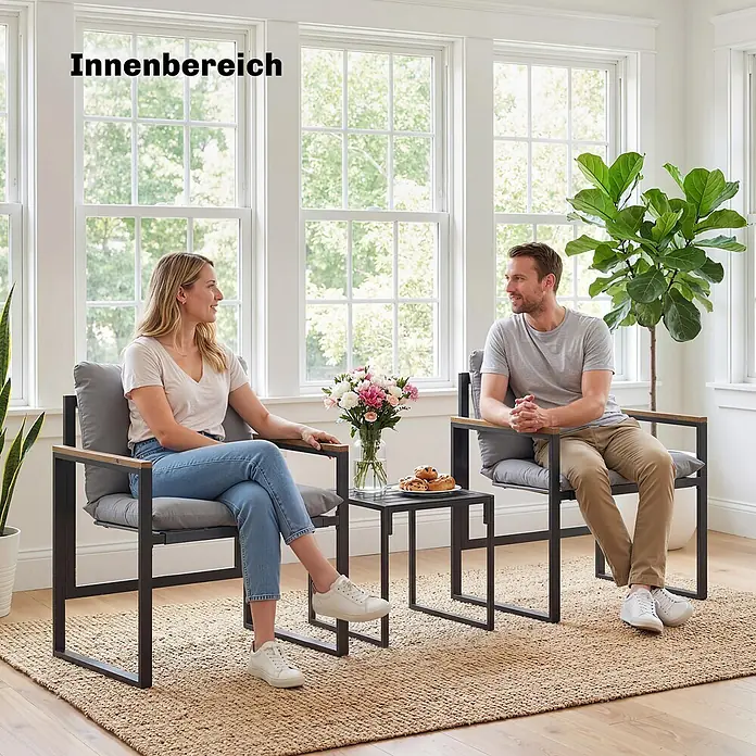 Outsunny Loungemöbel-Set - Grau - Paar nutzt zwei moderne Stühle mit schwarzen Gestellen, Holzarmlehnen, grauen Kissen und passenden schwarzen Beistelltisch im Innenbereich.