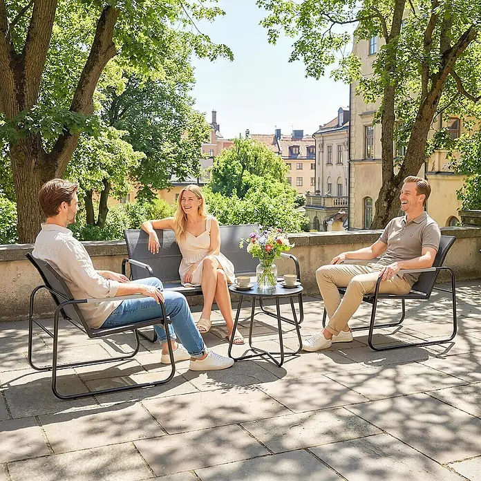 Outsunny Loungemöbel-Set - Verzinkter Stahl, Netzstoff, Grau - Drei Personen unterhalten sich draußen auf dunkelgrauen Terrassenstühlen mit Metallrahmen und einem passenden kleinen Tisch mit Tassen und Blumen.