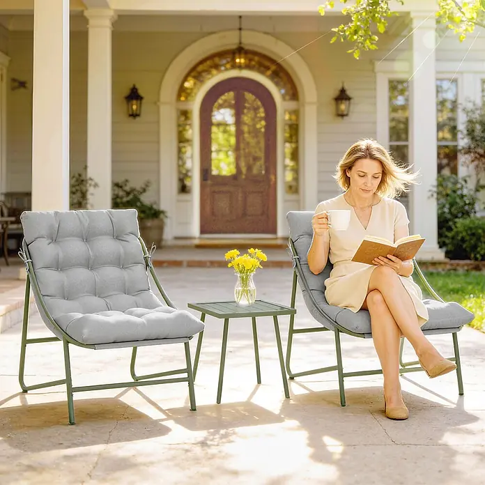 Outsunny Loungemöbel-Set - Hellgrau - Zwei grüne Outdoor-Loungesessel mit grauen Kissen und ein passender grüner Beistelltisch auf einer sonnigen Terrasse. Eine Frau entspannt in einem Sessel.