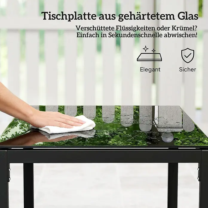 Outsunny Loungemöbel-Set - PE-Rattan, Hellgrau - Hand wischt verschüttete Flüssigkeit von gehärteter Glastischplatte mit weißem Tuch ab, was die reinigungsfreundliche Oberfläche und das elegante Design mit schwarzem Rahmen hervorhebt.