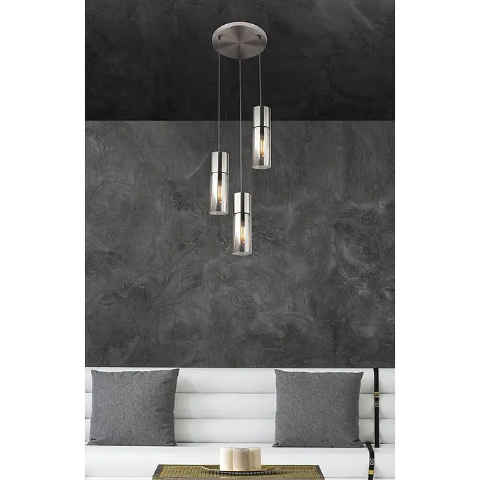 Globo Pendelleuchte Annika - 25 W, Ø x H: 30 x 150 cm - Drei zylindrische Pendelleuchten mit gebürsteten Metalloberteilen und Klarglasschirmen beleuchten einen modernen Wohnraum über einem Sofa.