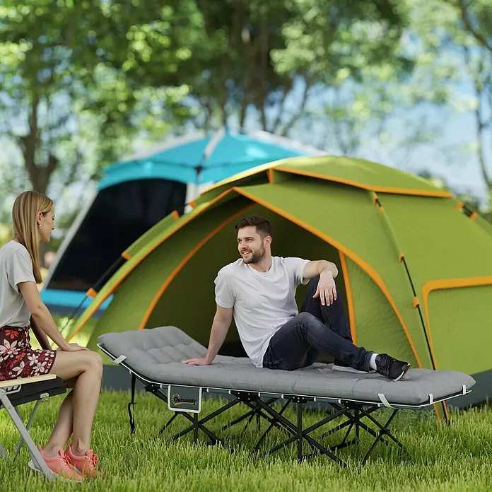 Outsunny Campingliege - Hellgrau, Metall, Klappbar - Mann entspannt auf einer grauen tragbaren Campingliege mit Polsterauflage im Freien, neben einem Zelt.
