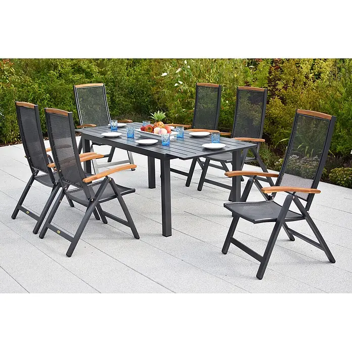 Merxx Gartentisch-Set Tilos - Gesamtumfang: 7 -tlg., Aluminium/Akazie, Klappbar - Dunkelgraues Outdoor-Essset mit Holzapplikationen auf einer Terrasse, mit Tellern, Gläsern und Obst gedeckt.