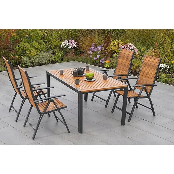 Merxx Gartentisch-Set Santorin - Gesamtumfang: 5 -tlg., Aluminium/Akazie, Klappbar - Gartengarnitur: Holztisch und vier passende Stühle mit dunklen Metallgestellen auf einer Terrasse im Grünen.