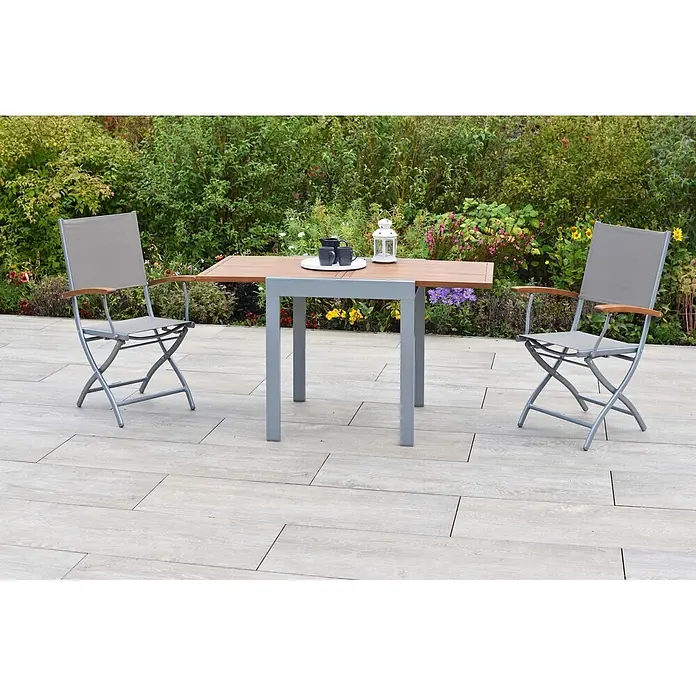 Merxx Gartentisch-Set Naxos - Gesamtumfang: 3 -tlg., Aluminium/Akazie/Textil, Klappbar - Outdoor-Essgruppe aus Grau und Holz mit Lattenrosttisch und zwei Klappstühlen auf einer Terrasse.