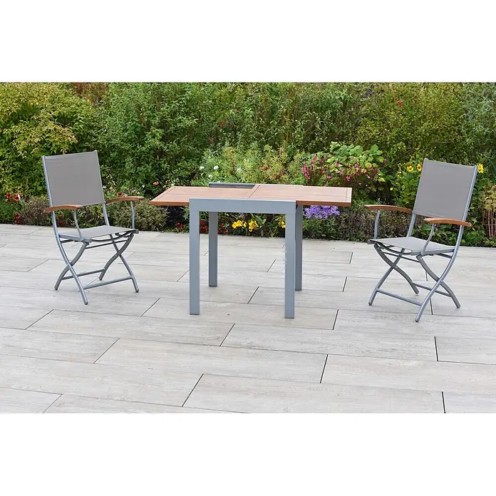Merxx Gartentisch-Set Naxos - Gesamtumfang: 3 -tlg., Aluminium/Akazie/Textil, Klappbar - Zwei graue Klappgartenstühle mit Holzarmlehnen und passendem Gartentisch aus Holzlatten und grauem Metall auf einer Terrasse.