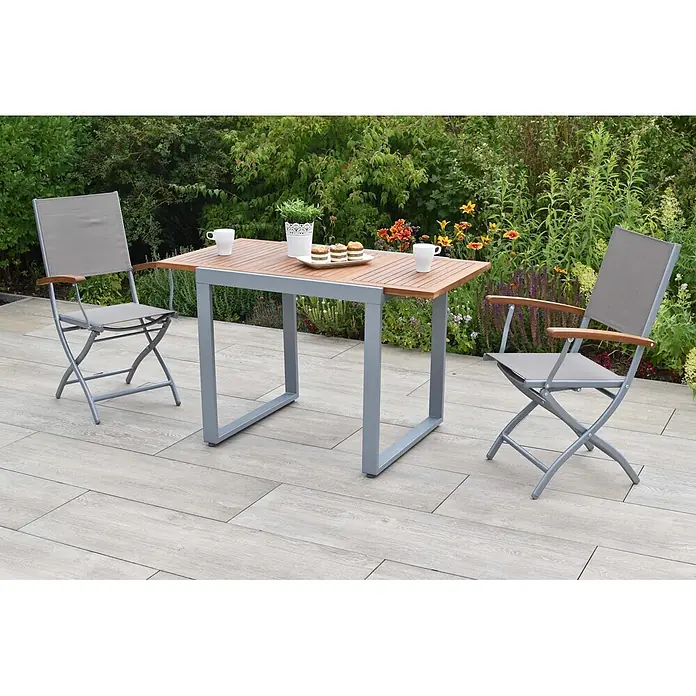 Merxx Gartentisch-Set Naxos - Gesamtumfang: 3 -tlg., Aluminium/Akazie/Textil, Klappbar - Garten-Essgruppe mit Holztisch und zwei klappbaren Stühlen aus grauem Stoff und Metall mit Holzarmlehnen auf einer Terrasse.