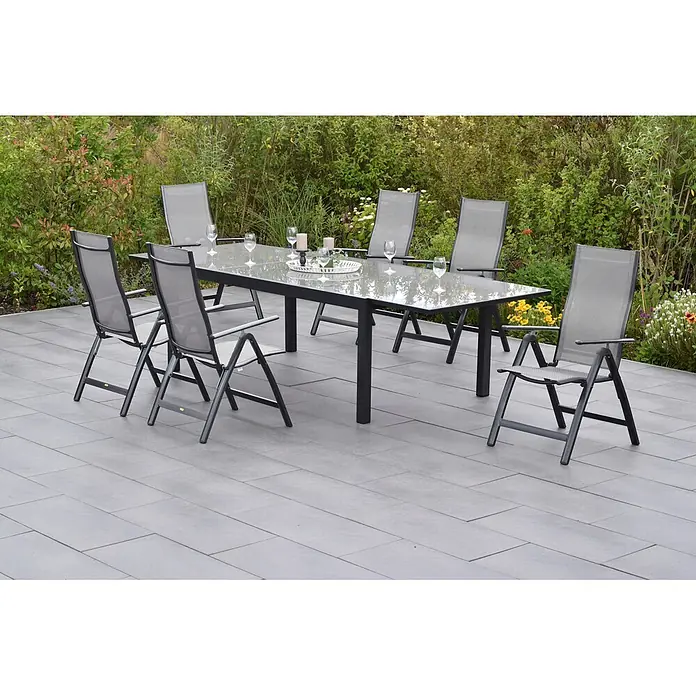 Merxx Gartentisch-Set Carrara - Gesamtumfang: 7 -tlg., L x B x H: 300 x 110 x 75 cm, Aluminium/Textil, Klappbar - Gartenset mit Glastisch und sechs grauen Mesh-Klappstühlen auf einer Terrasse.
