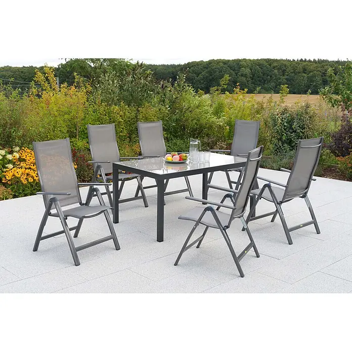 Merxx Gartentisch-Set Carrara - Gesamtumfang: 7 -tlg., L x B x H: 150 x 90 x 72 cm, Aluminium/Textil, Klappbar - Graues Garten-Essset mit Glastisch und sechs Stühlen auf einer Terrasse, umgeben von Gartenlaub.