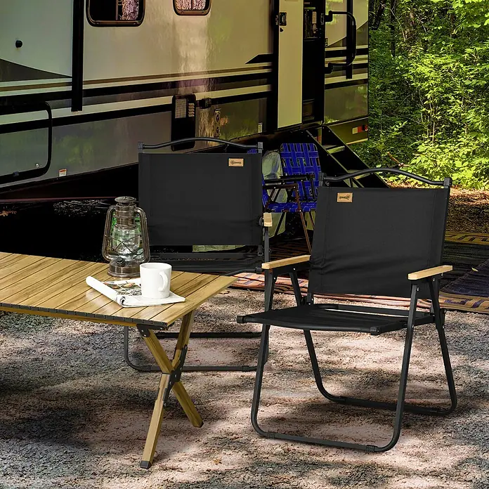 Outsunny Campingstuhl - Schwarz - Zwei schwarze Campingstühle mit Holzarmlehnen und ein Holztisch vor einem Wohnmobil.