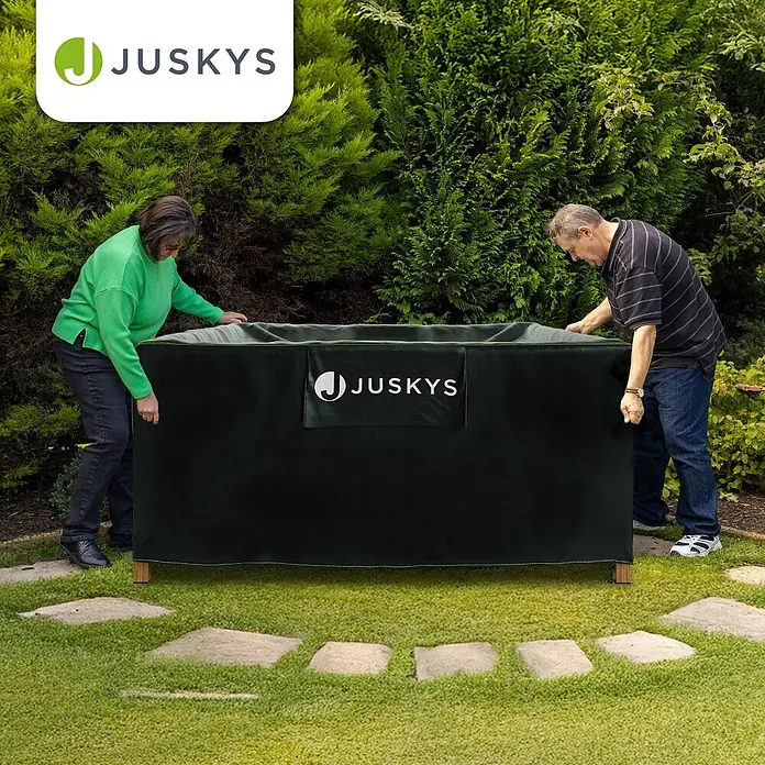 Juskys Loungemöbel-Schutzhülle CoverSafe - L x B x H: 242 x 162 x 100 cm, Material: 420D Oxford-Gewebe (100 g\m2), PU-Beschichtung, 100 g/m², schwarz - Zwei Personen handhaben eine große, schwarze JUSKYS Outdoor-Aufbewahrungsbox-Abdeckung.