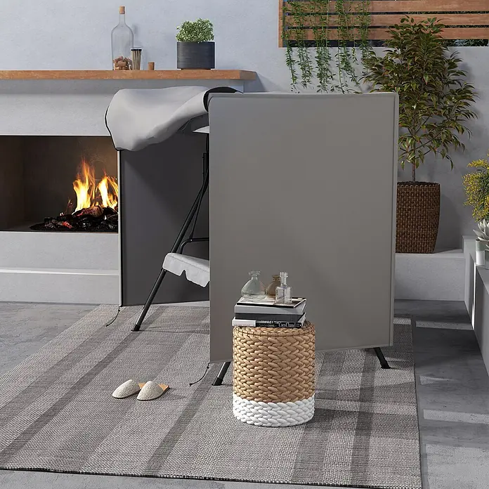 Outsunny Hollywoodschaukel-Schutzhülle - 420D Oxford Gewebe, 1.387 g/m², Hellgrau - Ein grauer faltbarer Paravent/Raumteiler auf einer Terrasse neben einem Kamin. Er dient als Sichtschutz.