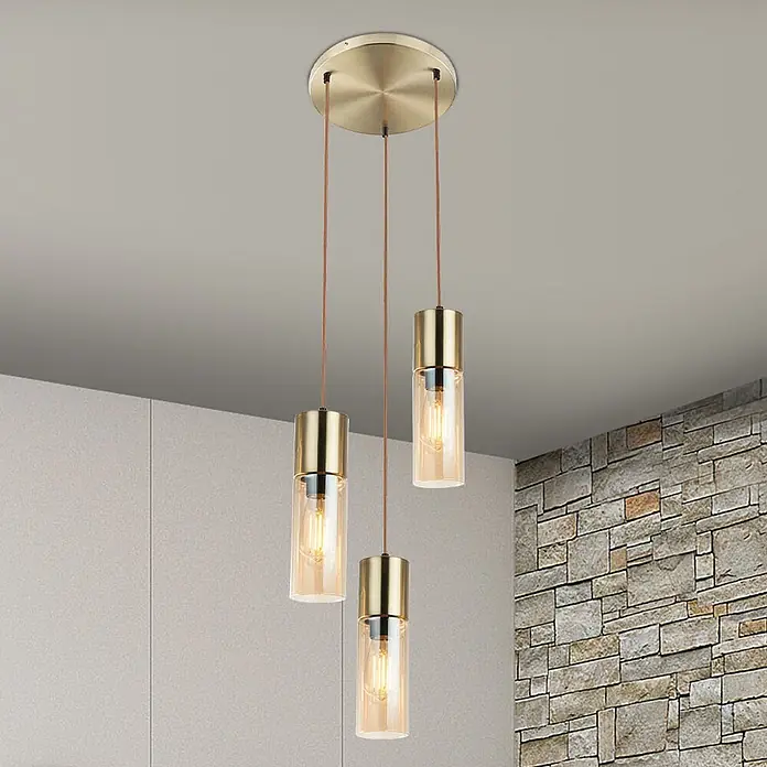 Globo Pendelleuchte Annika - 25 W, Ø x H: 30 x 150 cm - Drei messingfarbene Pendelleuchten mit bernsteinfarbenen Glasschirmen hängen von einer Decke in einem modernen Raum.