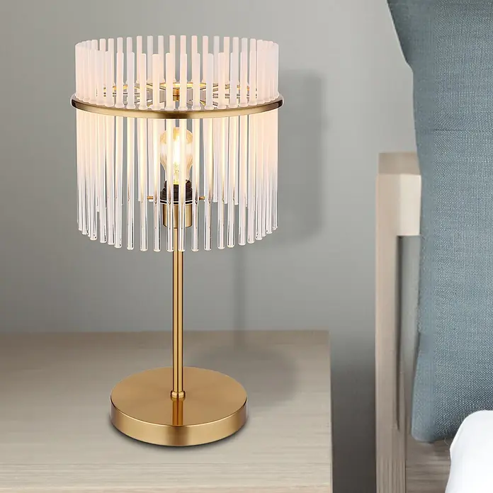 Globo Tischleuchte Gorley - 60 W, E27 - Goldene Tischlampe mit zylindrischem Schirm aus klaren und mattierten Glasstäben, beleuchtet auf einem Nachttisch.