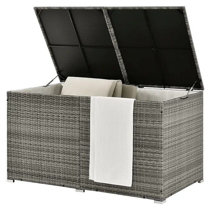 Juskys Garten-Aufbewahrungsbox Ikaria - grau, Kunststoff - Graue Rattan-Optik Outdoor-Aufbewahrungsbox mit offenem Deckel, innen Kissen und ein weißes Handtuch hängend.